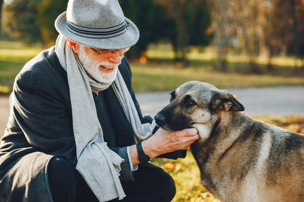 Older man feeling happy with his dog