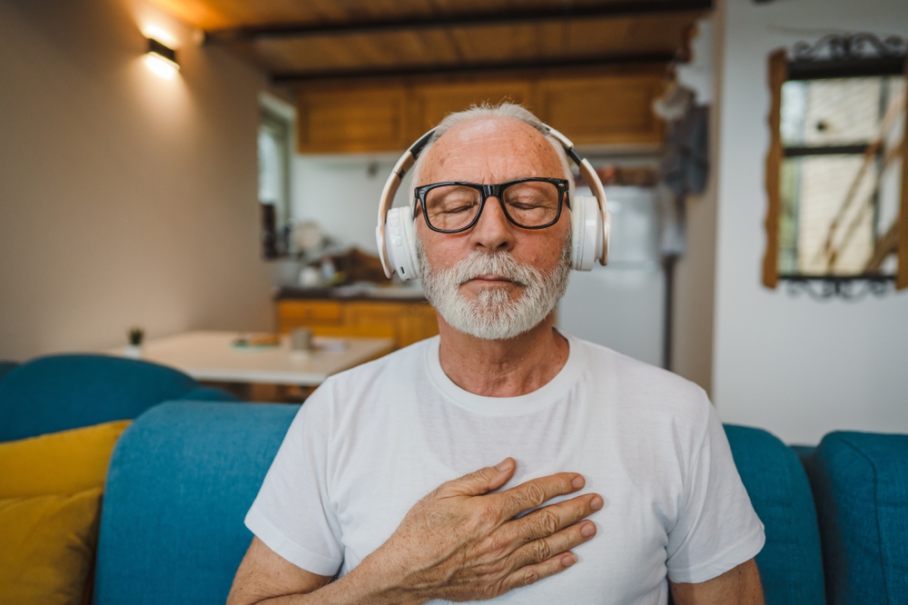 Mental wellness: elderly man listening to music and practising mindfulness
